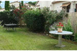 a table with a vase on it in a yard at Maison classée meublé 3 étoiles, proche mer. in Sainte-Maxime