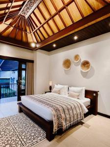 a bedroom with a large bed with a wooden ceiling at Villa Sriwedari - Seminyak in Seminyak +29 photos