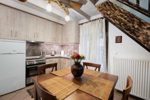 a kitchen with a table with a vase of flowers on it at Chalet Renata 1 Livadi Arachovas in Kalívia