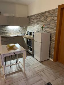 a kitchen with a white refrigerator and a table at Apartment Adam & Eva in Piešťany