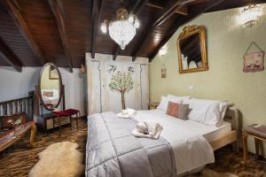 ein Schlafzimmer mit einem großen Bett und einem Kronleuchter in der Unterkunft Chalet Renata 1 Livadi Arachovas in Kalívia