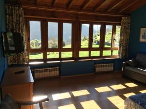 a living room with a large window and a couch at LA LLANADA in Cangas de Onís