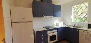 トレリャ・デ・モングリにあるCasa Mas Pinell 93のキッチン(青いキャビネット、白い冷蔵庫付)