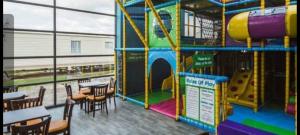 un restaurante con un parque infantil con mesas y sillas en Millie’s caravan en Abergele