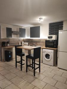 cocina con mesa, sillas y nevera en appartement calme de 48m2, en Amélie-les-Bains-Palalda