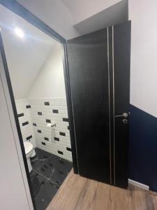 a bathroom with a toilet and a black shower door at Cocoon’in in Raismes