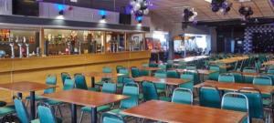 um restaurante vazio com mesas e cadeiras e um bar em Kens caravan em Abergele