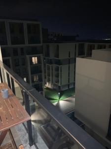 balcón con mesa y algunos edificios por la noche en Lovely Duplex Guesthouse in Bursa, en Gorukle