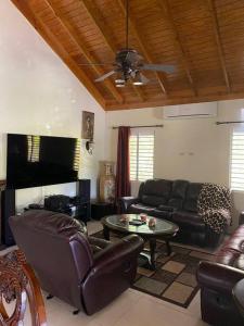 a living room with leather furniture and a ceiling at Sunset Palms by Richmond Estate in Richmond