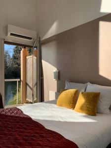 a bedroom with a large bed with a window at Hôtel L'ile Du Saussay in Itteville