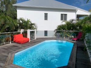 a swimming pool in front of a house at Le Cosmopolitain_ Appart 4/5p terrasse piscine in Cul de Sac
