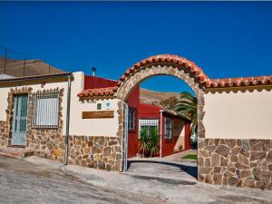 a house with an archway in front of a building at Casa La Ronda. in Jódar