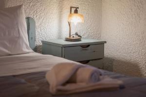 ein Schlafzimmer mit einem Bett mit einer Lampe auf einer Kommode in der Unterkunft Chalet Renata 2 Livadi Arachovas in Kalívia