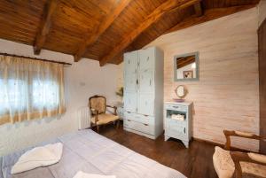 ein Schlafzimmer mit einem Bett, einem Schrank und einem Schreibtisch in der Unterkunft Chalet Renata 2 Livadi Arachovas in Kalívia