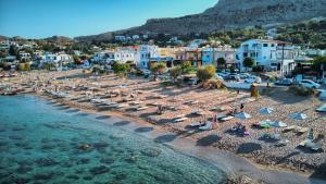 an aerial view of a beach with chairs and umbrellas at summer paradise stegna rhodes in Archangelos