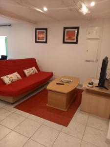sala de estar con sofá rojo y mesa en Ile breizh, en Ploubezre