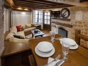 a living room with a table and a fireplace at Arachova Nest in the Village in Arachova