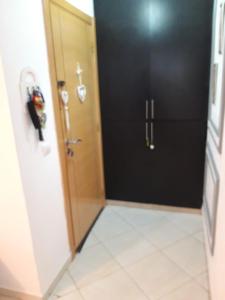 a bathroom with a black door and a tile floor at Appartement Adrar in Agadir