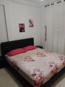 a bedroom with a large bed with red pillows at Appartement Adrar in Agadir