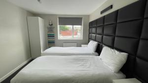 a bedroom with two beds and a window at Hosted By Ryan - 1 Bedroom Apartment in Liverpool