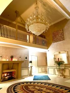 a large living room with a chandelier and a fireplace at FINN VILLAGE - Loch Lomond Villa B&B with a Hot Tub in Glasgow