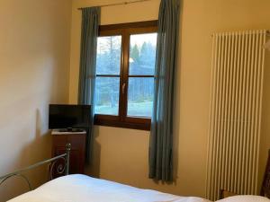 a bedroom with a bed and a window at la casetta sulla neve in Abetone
