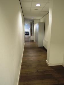 an empty hallway in an office building with wood floors at 3BE Backpackers Bed & Breakfast Eindhoven in Eindhoven