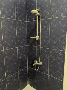 y baño con ducha y paredes de azulejos negros. en Heliopolis Residence Shrouk city Cairo, en Madīnat ash Shurūq