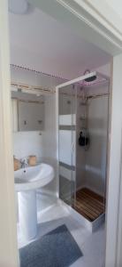 uma casa de banho branca com um chuveiro e um lavatório. em La loggetta 63 em Palagianello