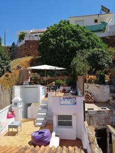 un patio con mesa y sombrilla en CASA DA MURALHA, en Silves