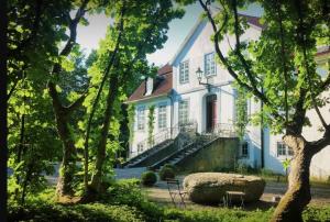 a large white house with a staircase in front of it at Castle Apartment in Österlen - The Thott Suite in Tomelilla