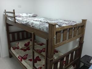 a bunk bed in a room with a bedspread with flowers at Apartahotel in Taganga