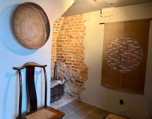 una habitación con una pared de ladrillo con una silla y una pared con artefactos en Castle Apartment in Österlen - The Thott Suite, en Tomelilla