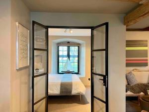 - une chambre avec un lit et une porte en verre dans l'établissement Castle Apartment in Österlen - The Thott Suite, à Tomelilla