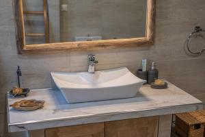 un lavandino bianco in un bagno con uno specchio di Villa Dianne Apt 1 Livadi Arachovas ad Aráchova