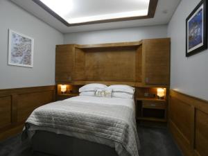 - une chambre avec un grand lit et une tête de lit en bois dans l'établissement Lorne View, à Oban