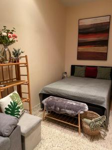 a living room with a bed and a chair at Jungle Story Apartment by Millenaris Park with Free Parking in Budapest