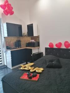 een slaapkamer met een zwart bed met schoenen en een dienblad bij Apartament Czarny in Bydgoszcz
