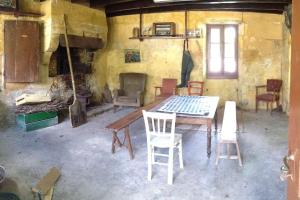 Pokój ze stołem, krzesłami i kominkiem w obiekcie Chambres en maison d'hôtes Le Moulin d'Annepont w mieście Annepont