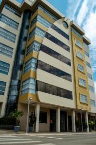 ein gelbes und weißes Gebäude mit einer Uhr drauf in der Unterkunft Hotel Ceibo Dorado in Portoviejo