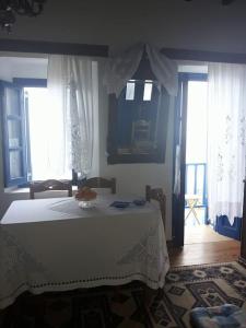 a bedroom with a white bed and two windows at Emporios Traditional Sea View House in Emporeiós