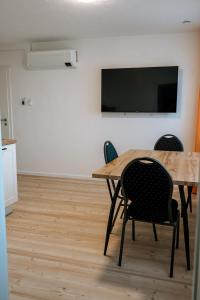 einen Konferenzraum mit einem Tisch und Stühlen sowie einem Flachbild-TV in der Unterkunft Dill Apartments Ilsede in Ilsede