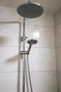 a shower with a shower head in a bathroom at Dill Apartments Ilsede in Ilsede