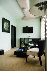 a living room with a chair and a table at Hotel Ceibo Dorado in Portoviejo