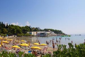 een groep mensen op een strand met parasols bij Apartman Drago 4* - 2 minutes from the town centre in Split