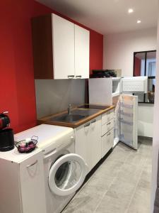 a kitchen with a washing machine and a sink at Studio Rez de jardin dans résidence privée près de la plage in Calvi