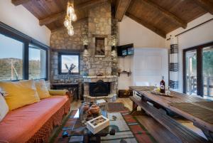 un soggiorno con divano e camino in pietra di Villa Dianne Apt 2 Livadi Arachovas ad Aráchova Altre 21 foto