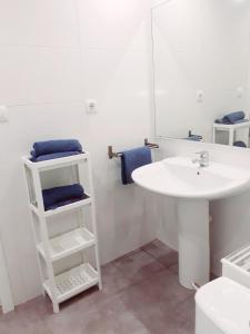 Baño blanco con lavabo y espejo en Rainbow Rentals Marques 7, en Benidorm