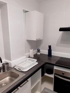 a small kitchen with white cabinets and a sink at Rainbow Rentals Marques 7 in Benidorm