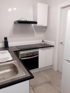 a white kitchen with a sink and a stove at Rainbow Rentals Marques 7 in Benidorm